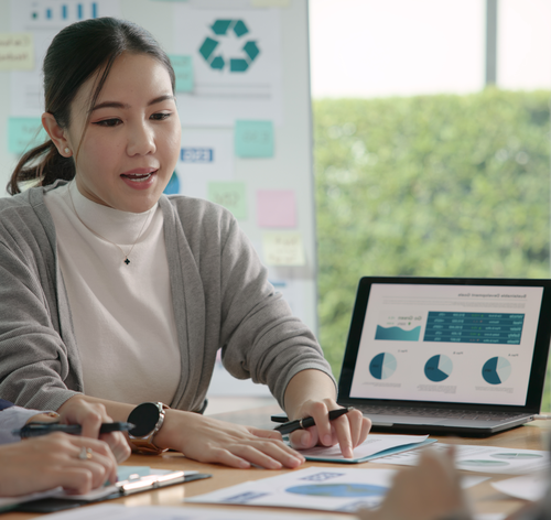 Drei Personan am Tisch analysieren Charts